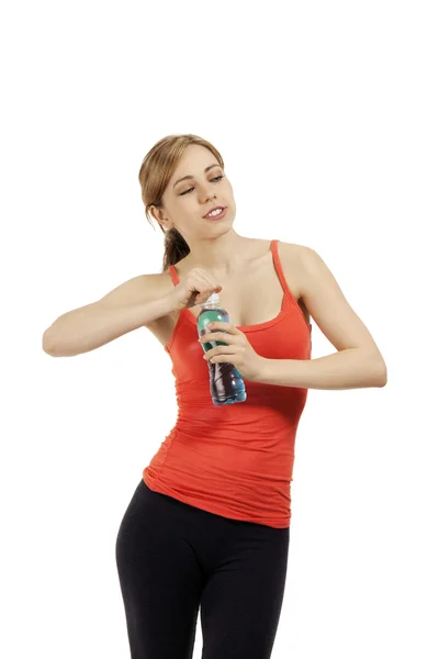 Fitness woman opening a bottle of water looking to side — Stock Photo, Image