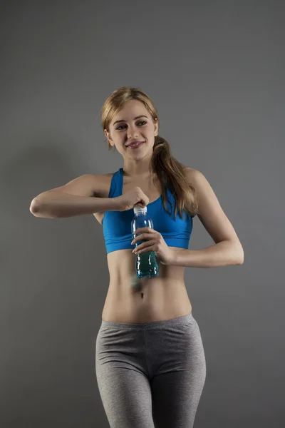 Junge Fitness-Frau öffnet Flasche mit Wasser — Stockfoto