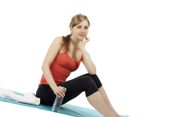 Fitness mladá žena sedí s lahví vody — Stock fotografie