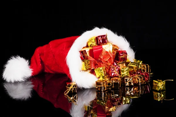 Christmas gifts falling from santa's hat — Stock Photo, Image