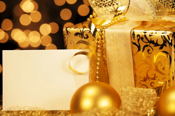 Golden christmas present with christmas balls — Stock Photo, Image