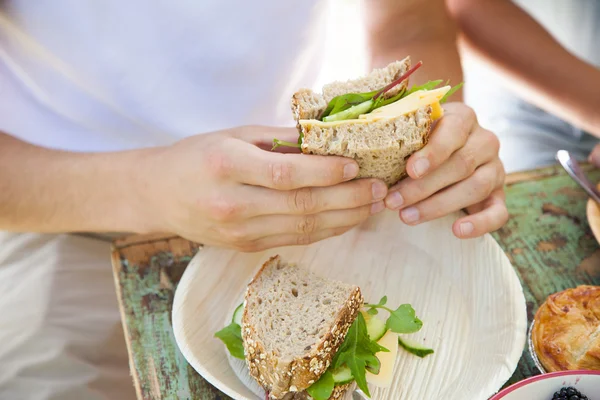 Αρσενικό χέρια που κρατούν ένα σάντουιτς — Φωτογραφία Αρχείου