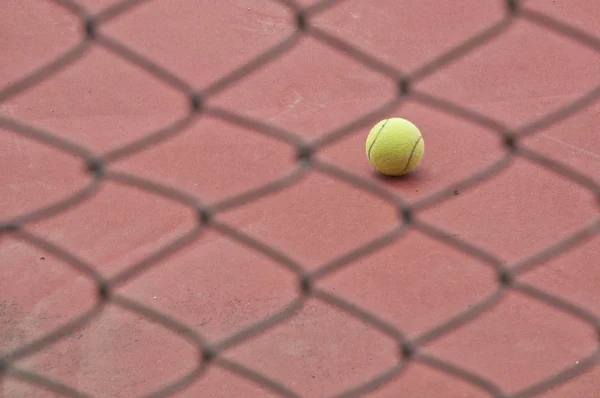 Tennis ball behind the net — Stock Photo, Image