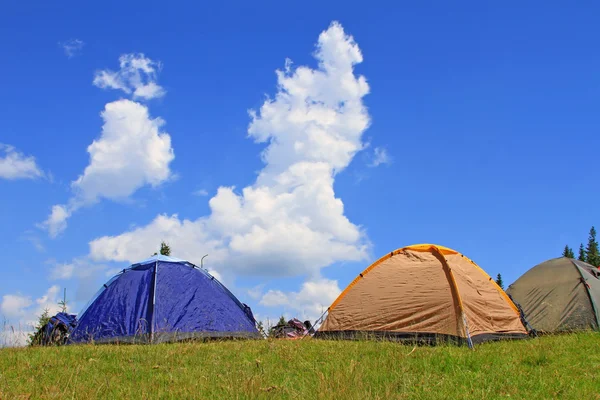 stock image Tent of tourists on a green slope.