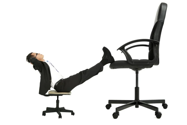 Üzletember, a kis szék lábát a nagy székre ült, és gondolkodás támogatása — Stock Fotó