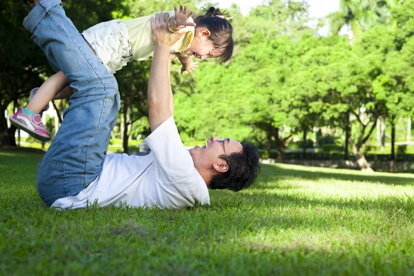 Heureux père et petite fille sur l'herbe — Photo