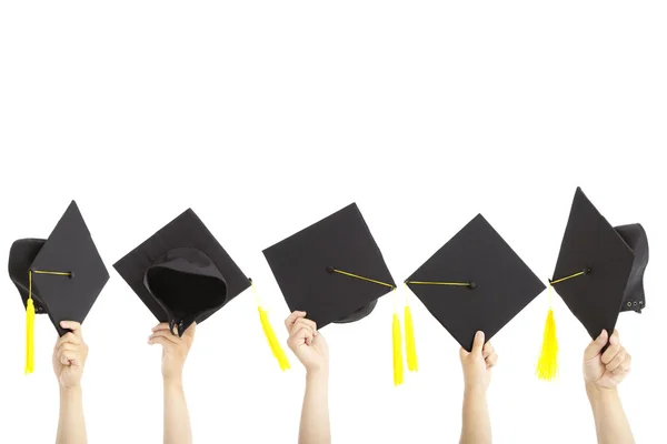 Muitos mão segurando chapéus de graduação e isolado em branco — Fotografia de Stock