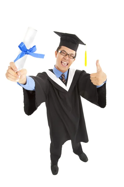 Happy graduating student holding diploma with thumbs up — Stock Photo, Image