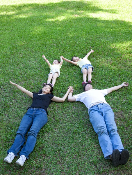 Rodziny azjatyckie, leżąc na trawie — Zdjęcie stockowe