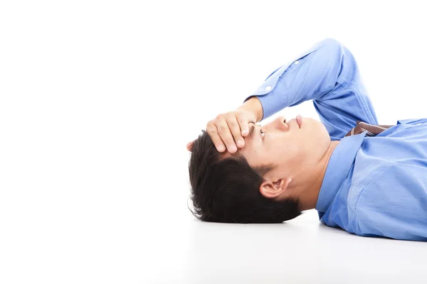 Zakenman liggend op de vloer met hoofdpijn — Stockfoto