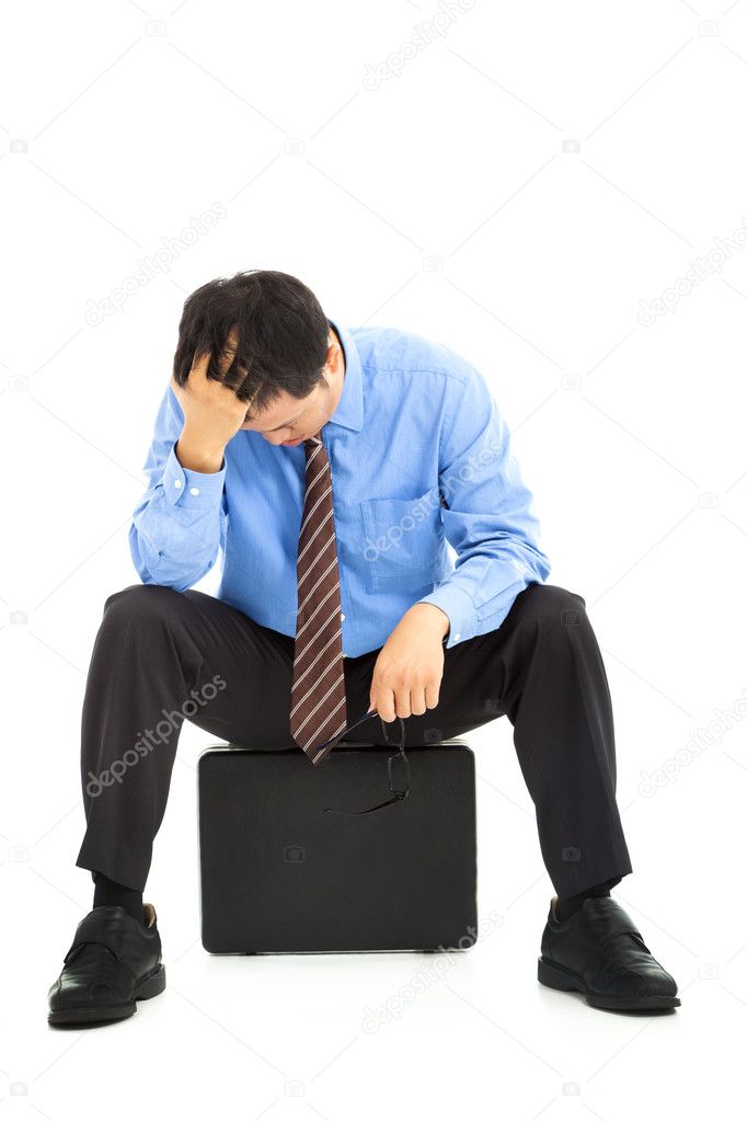 Frustrated businessman sitting on the briefcase