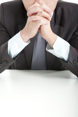 Businessman in thinking with hand on the office desk clipart