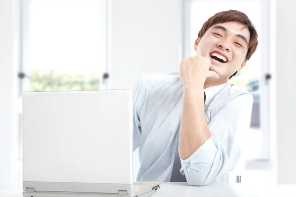 Щасливий бізнесмен, що працює з комп'ютером в офісі — стокове фото