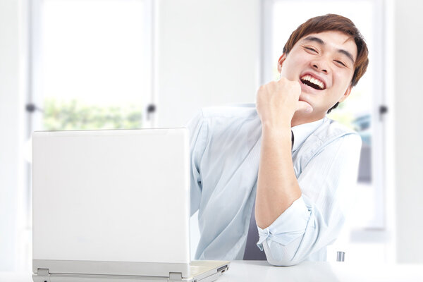 Happy businessman working with computer in the office