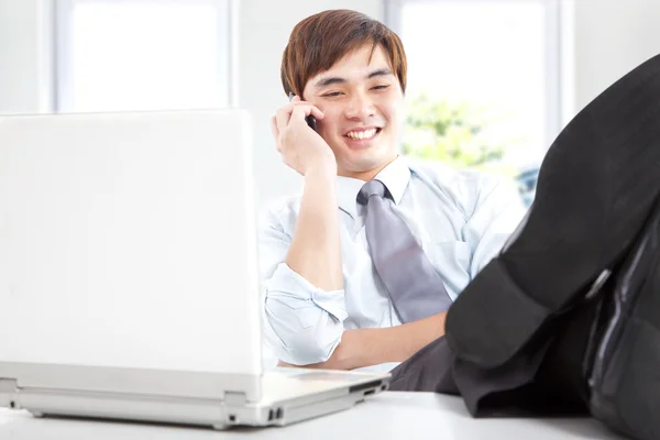 Empresário feliz tomando um telefonema no escritório — Fotografia de Stock