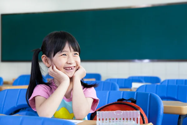 Счастливая маленькая девочка в классе — стоковое фото
