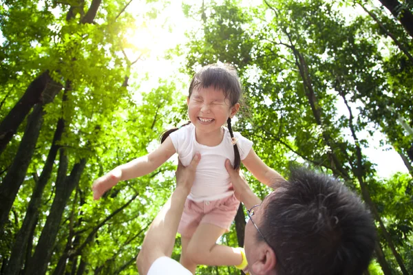 Glad liten flicka med far i den gröna skogen på morgonen — Stockfoto