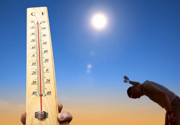 Mann übergießt sich mit Wasser zur Abkühlung bei Hitze und Sommerhimmel — Stockfoto