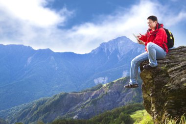 Man with tablet pc on the mountain clipart