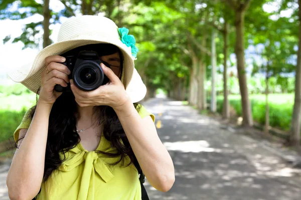 Молодой путешественник фотографирует в зеленом лесу — стоковое фото