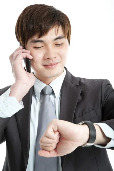 Azjatycki biznesmen sprawdzania czasu podczas rozmowy na telefon komórkowy — Zdjęcie stockowe