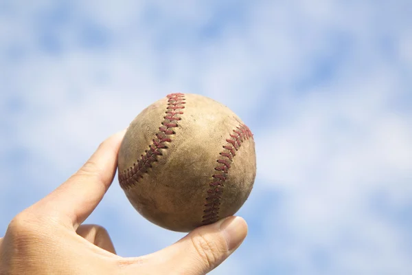stock image Hand holding old baseball with cloud background