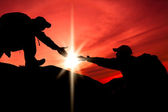 Silhouette der helfenden Hand zwischen zwei Bergsteigern