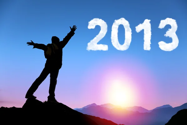 Ευτυχισμένο το νέο έτος 2013. νέος άνθρωπος στέκεται στην κορυφή βουνού, βλέποντας την Ανατολή του ηλίου και σύννεφο 2013 — Φωτογραφία Αρχείου