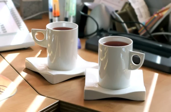 Foto einer Teetasse mit schwarzem Tee im Büro — Stockfoto