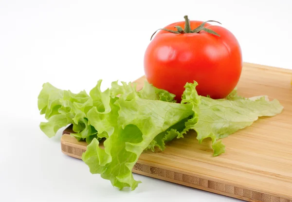 Tomaten- und Salatblatt auf einem Holzbrett — Stockfoto
