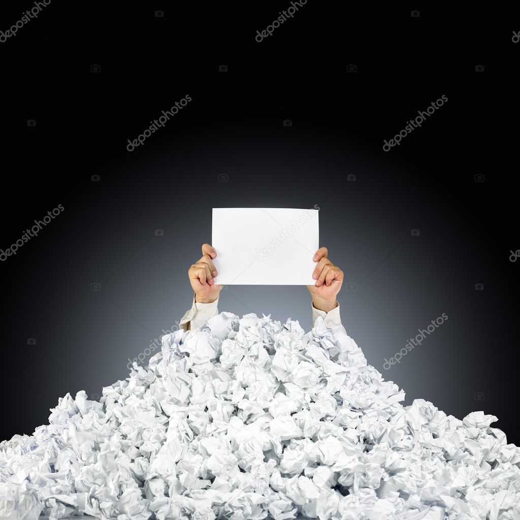Person under crumpled pile of papers with hand holding a help si