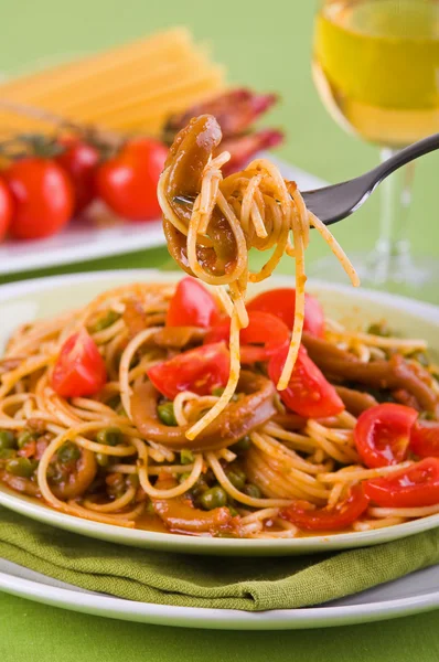 Špagety s kalamáry, hrášek a cherry rajčaty. — Stock fotografie