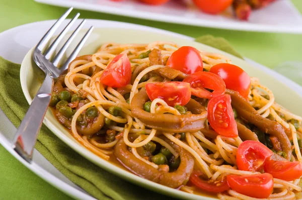 Spaghetti mit Tintenfisch, Erbsen und Kirschtomaten. — Stockfoto