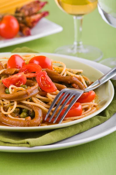 Espaguete com lulas, ervilhas e tomates cereja . — Fotografia de Stock