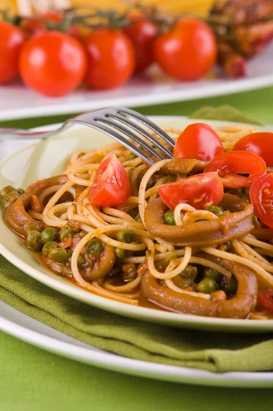 Spaghetti con calamari, piselli e pomodorini . — Foto Stock