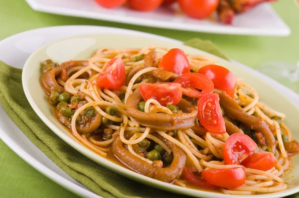 Espaguetis con calamares, guisantes y tomates cherry . — Foto de Stock