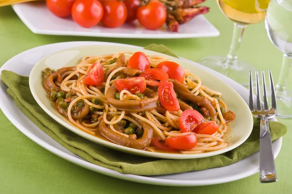 Spaghetti mit Tintenfisch, Erbsen und Kirschtomaten. — Stockfoto