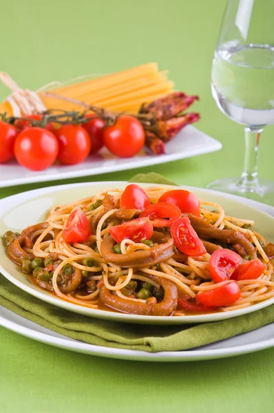 Espaguete com lulas, ervilhas e tomates cereja . — Fotografia de Stock