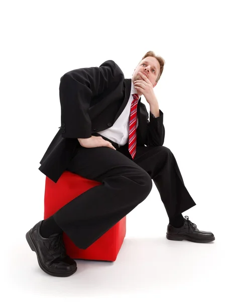Бізнесмен сидить на червоному табуреті — стокове фото