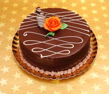 Chocolate cake on golden stars background clipart