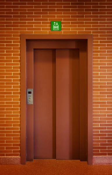 Porta do elevador em uma parede de tijolo — Fotografia de Stock