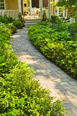 Stone path in landscaped home garden clipart