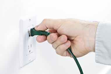 Hand inserting plug into outlet clipart