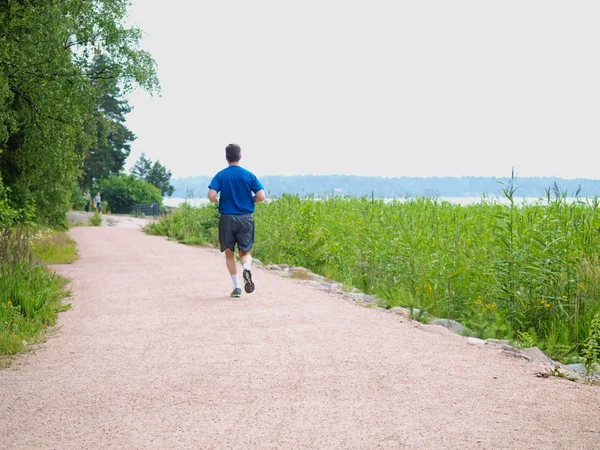 stock image Person running alone on gravel road, at summer