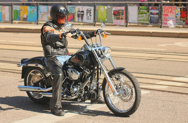 Мотоциклист, сидящий на тяжелом мотоцикле, полностью одетый в кожу — стоковое фото