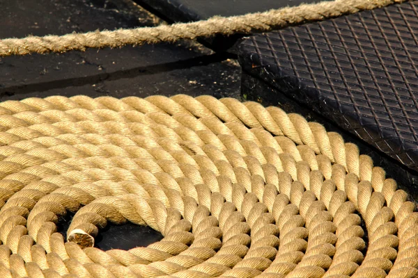 Primer plano de una vieja cuerda de barco deshilachada en círculo, en la cubierta de un barco — Foto de Stock
