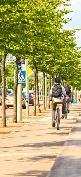 Motociclista su strada laterale, in centro città con alberi in mezzo — Foto Stock