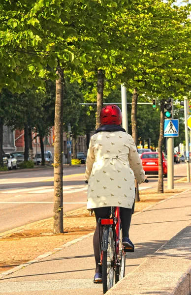 Rowerzysta na bocznej ulicy, w centrum miasta z pomiędzy drzew — Zdjęcie stockowe