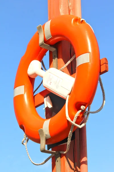 Life buoy attached to a pole towards blue sky — Stock Photo, Image