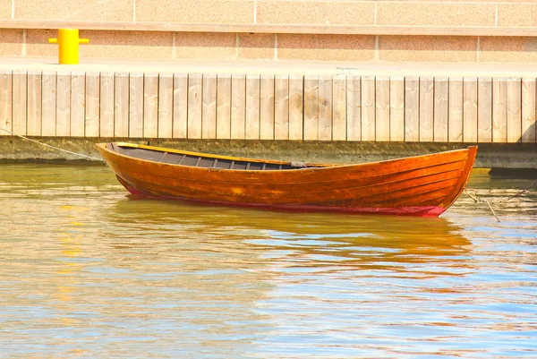 Een houten roeiboot tij neer in harbor — Stockfoto